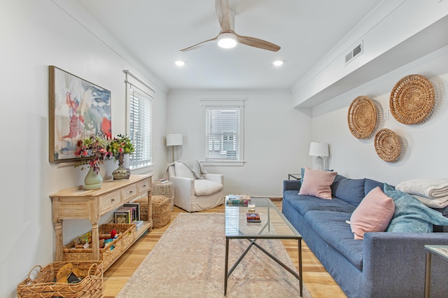 living room with ceiling fan, ornamental molding, and light hardwood / wood-style flooring