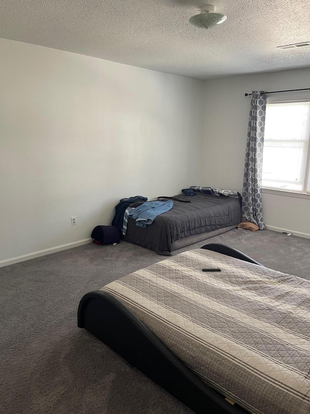 bedroom with a textured ceiling and carpet floors