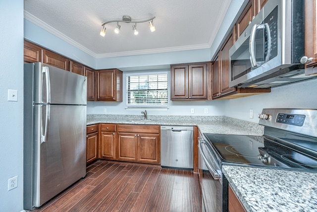 kitchen with dark hardwood / wood-style floors, a textured ceiling, appliances with stainless steel finishes, and crown molding