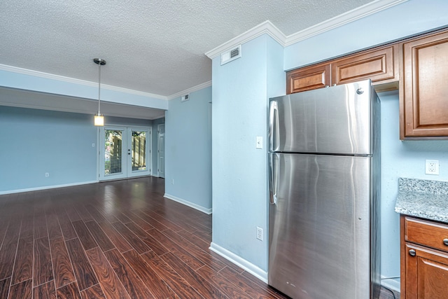 kitchen with light stone counters, a textured ceiling, dark hardwood / wood-style floors, crown molding, and stainless steel fridge