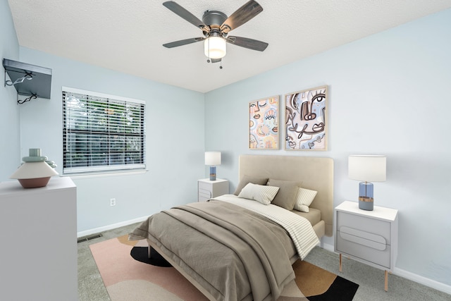 carpeted bedroom with a textured ceiling and ceiling fan