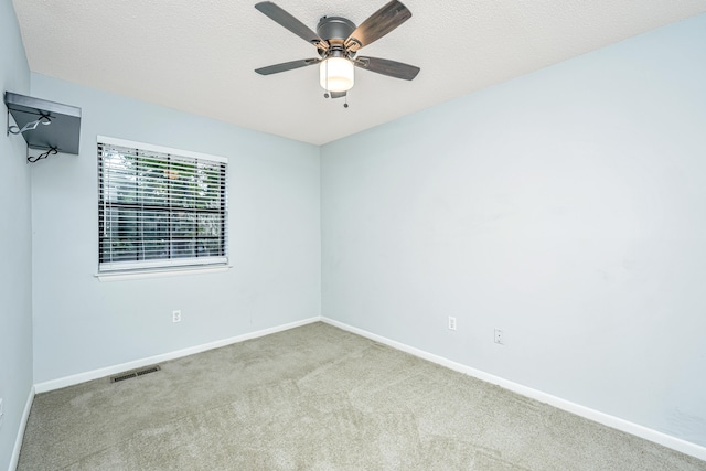 carpeted spare room with ceiling fan and a textured ceiling