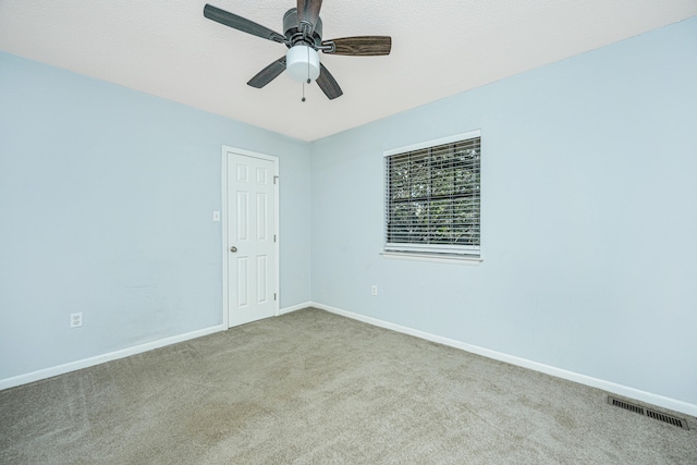 empty room featuring light colored carpet and ceiling fan