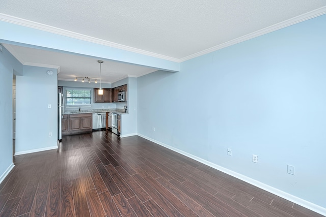 unfurnished living room with dark wood-type flooring, a textured ceiling, and ornamental molding