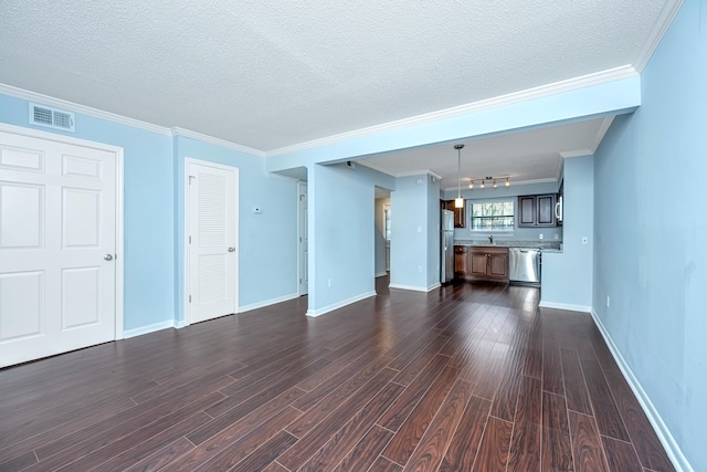 unfurnished living room featuring dark wood-type flooring, a textured ceiling, sink, and crown molding