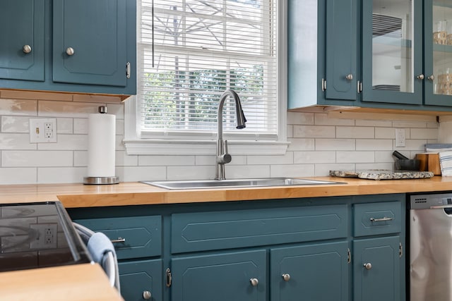 305 Forest Cir, Summerville, SC 29483 - kitchen with stainless steel dishwasher, a sink, tasteful backsplash, butcher block countertops, and glass insert cabinets