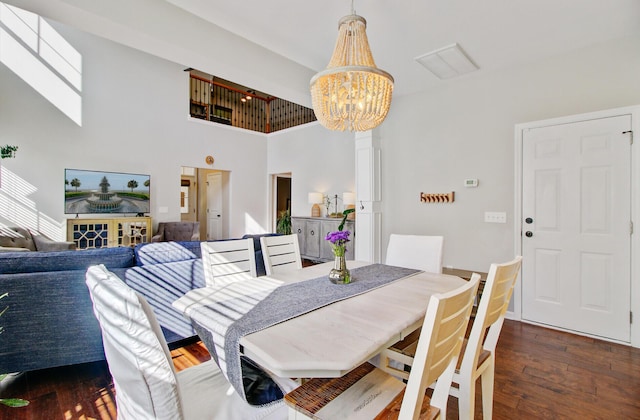 dining area with a high ceiling, wood-type flooring, and a chandelier