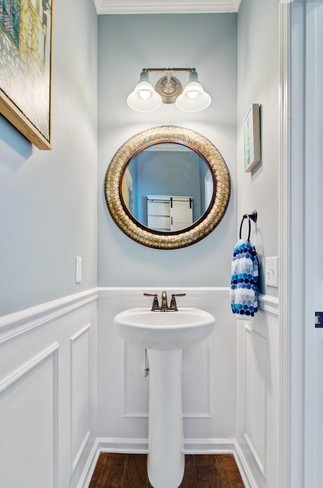 bathroom featuring a wainscoted wall and a decorative wall