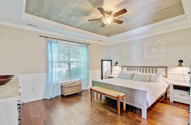 bedroom featuring visible vents, a raised ceiling, and hardwood / wood-style floors
