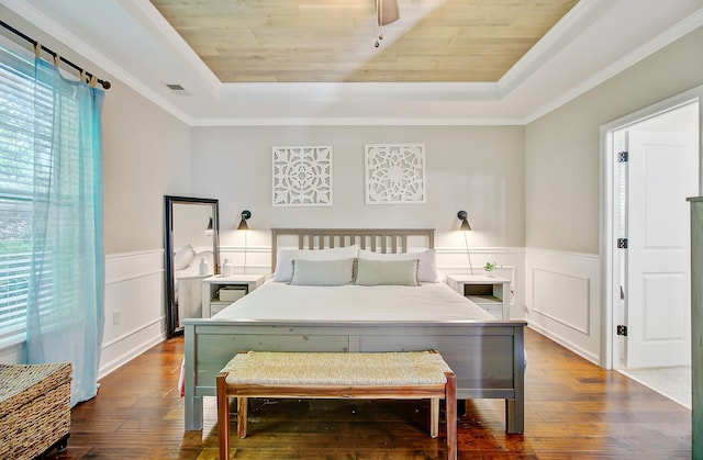 bedroom featuring visible vents, a decorative wall, a raised ceiling, wood ceiling, and hardwood / wood-style flooring