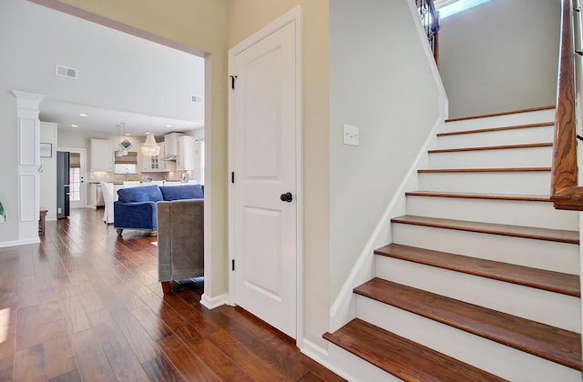 staircase featuring recessed lighting, visible vents, and wood finished floors