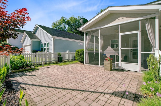 view of patio with fence and a sunroom