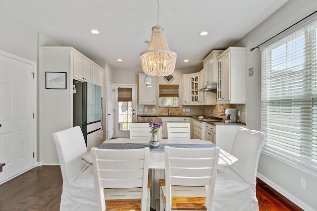 dining space featuring an inviting chandelier, dark wood-style flooring, and a wealth of natural light