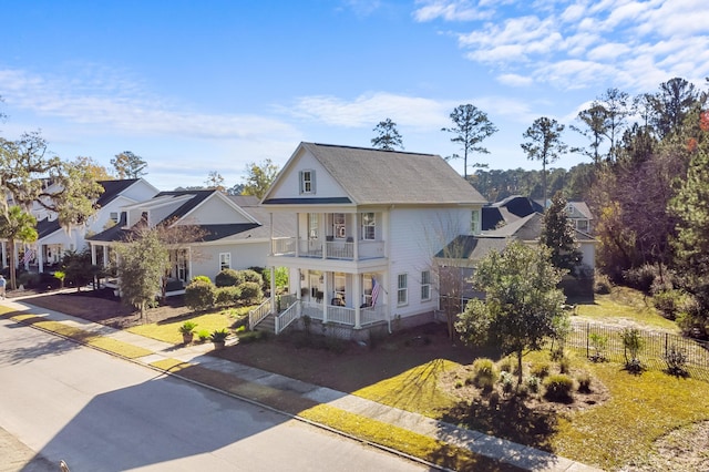 view of front of property featuring a porch, a balcony, and a front lawn