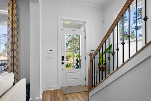 entrance foyer with light hardwood / wood-style floors and ornamental molding