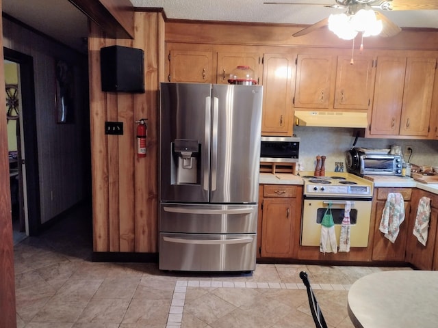 kitchen featuring a ceiling fan, under cabinet range hood, appliances with stainless steel finishes, a toaster, and light countertops