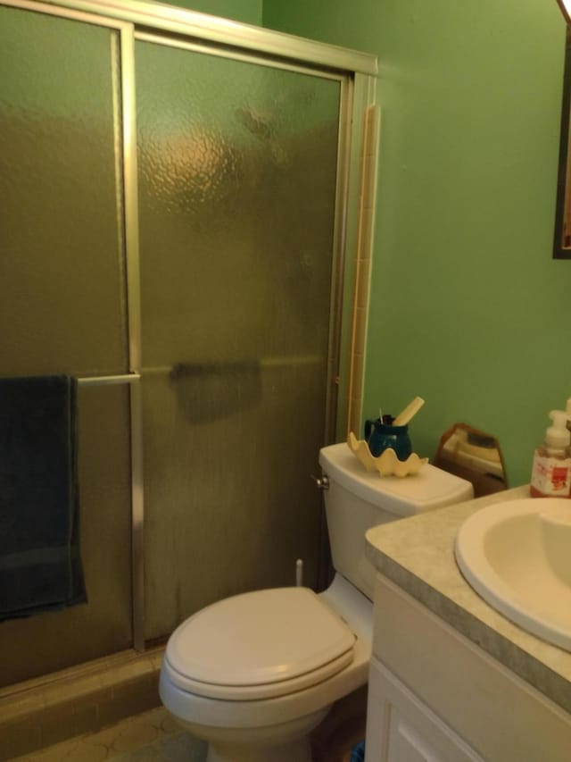 bathroom with toilet, a stall shower, and vanity