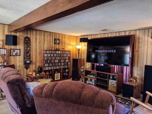 living area featuring beamed ceiling, a textured ceiling, and wooden walls