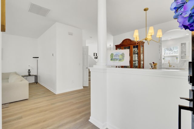 117 Red Leaf Blvd, Moncks Corner, SC 29461 - kitchen featuring light wood-type flooring, a chandelier, baseboards, hanging light fixtures, and a peninsula