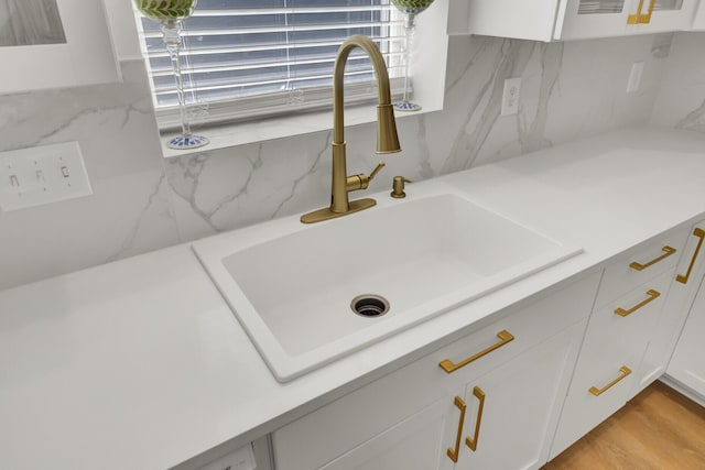 117 Red Leaf Blvd, Moncks Corner, SC 29461 - kitchen view of a sink, white cabinetry, decorative backsplash, and light stone counters