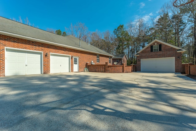 view of side of property featuring a shingled roof and brick siding