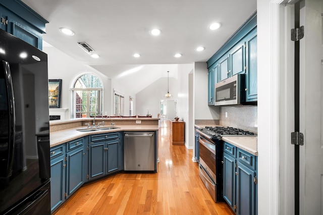 kitchen with blue cabinets, stainless steel appliances, a sink, visible vents, and light countertops