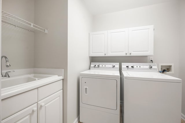 laundry room featuring cabinet space, independent washer and dryer, and a sink