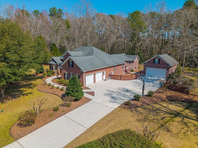 view of front of house featuring a front yard, brick siding, and driveway