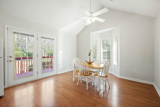 dining space with lofted ceiling, ceiling fan, wood finished floors, and baseboards