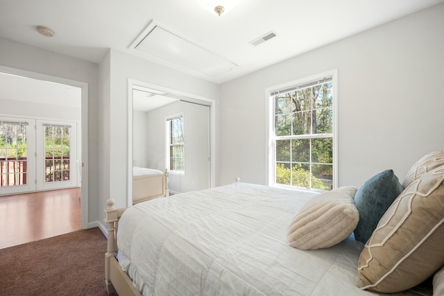 carpeted bedroom with baseboards, attic access, visible vents, and a closet