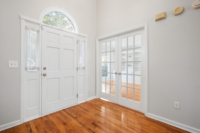 entrance foyer featuring french doors, baseboards, and wood finished floors