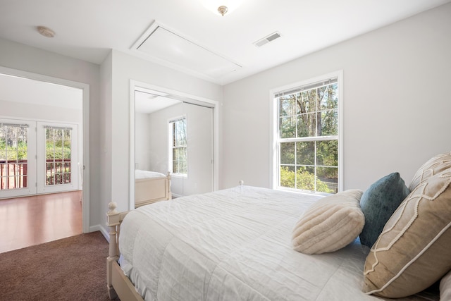 bedroom with carpet flooring, visible vents, baseboards, a closet, and attic access