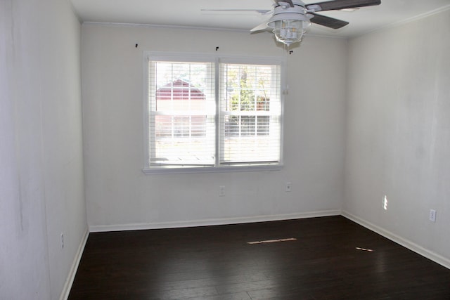 empty room featuring dark wood-type flooring, ornamental molding, and ceiling fan