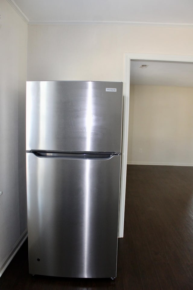 details with stainless steel refrigerator and dark wood-type flooring