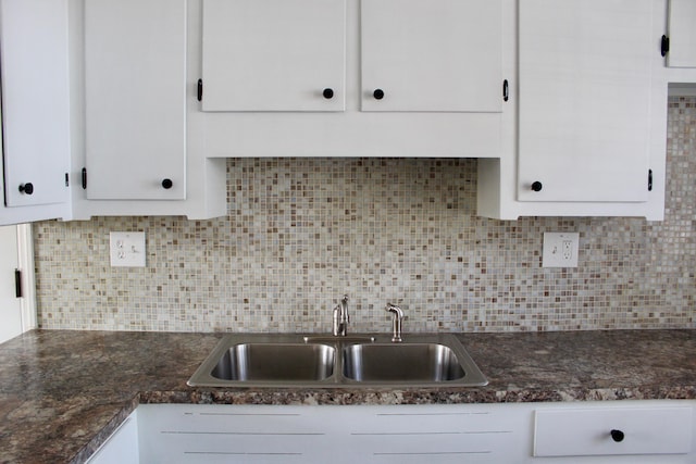 kitchen with sink, white cabinets, and backsplash