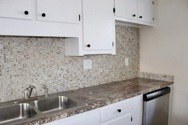 kitchen with sink, backsplash, white cabinets, stainless steel dishwasher, and dark stone counters