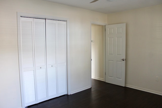 unfurnished bedroom with dark hardwood / wood-style floors and a closet