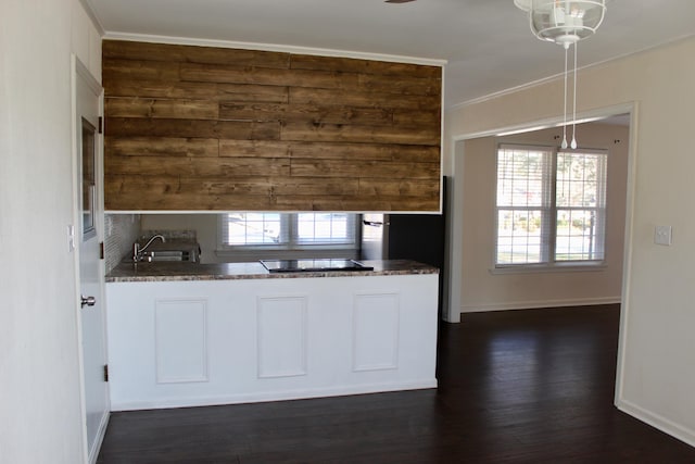 kitchen with pendant lighting, white cabinetry, ornamental molding, dark wood-type flooring, and black electric cooktop