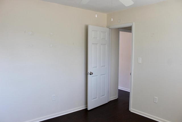 spare room with dark wood-type flooring and ceiling fan