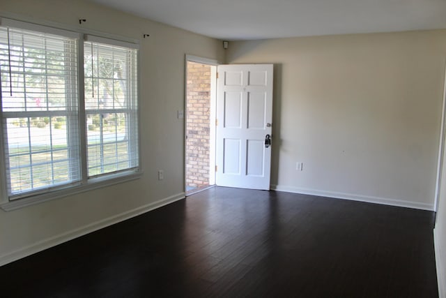 unfurnished room with plenty of natural light and dark hardwood / wood-style floors