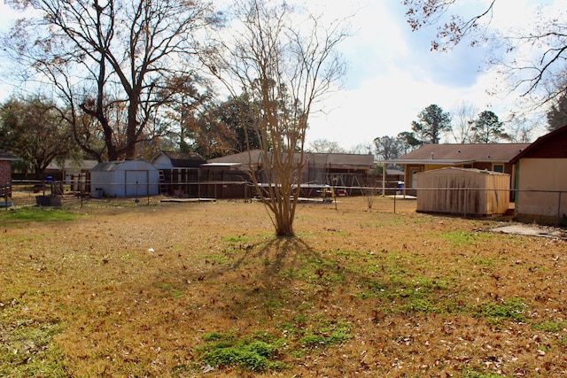 view of yard featuring a storage shed and a trampoline