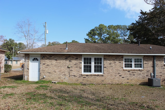 back of house featuring a yard and central AC unit