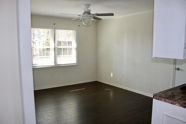 empty room with ceiling fan and dark hardwood / wood-style flooring