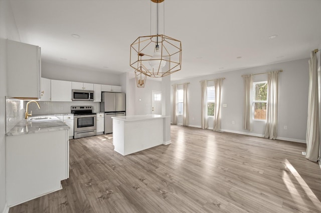 5748 Pilgrim Ave Unit D, Hanahan, SC 29410 - kitchen featuring appliances with stainless steel finishes, a sink, a kitchen island, light countertops, and tasteful backsplash