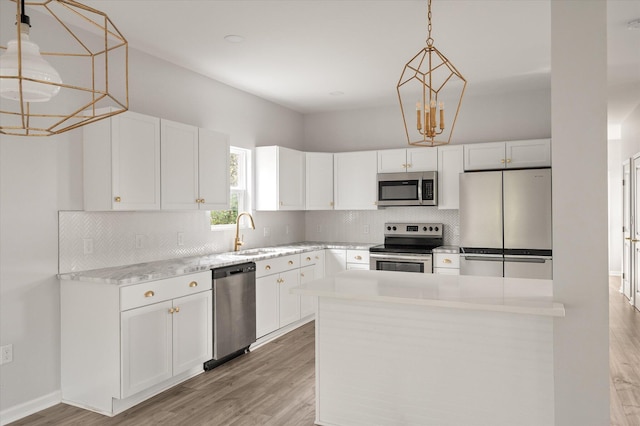 5748 Pilgrim Ave Unit D, Hanahan, SC 29410 - kitchen with stainless steel appliances, a sink, tasteful backsplash, light wood-style flooring, and white cabinets