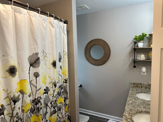 bathroom with walk in shower, vanity, and hardwood / wood-style floors