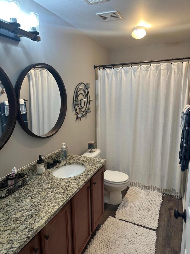 bathroom featuring hardwood / wood-style flooring, toilet, and vanity