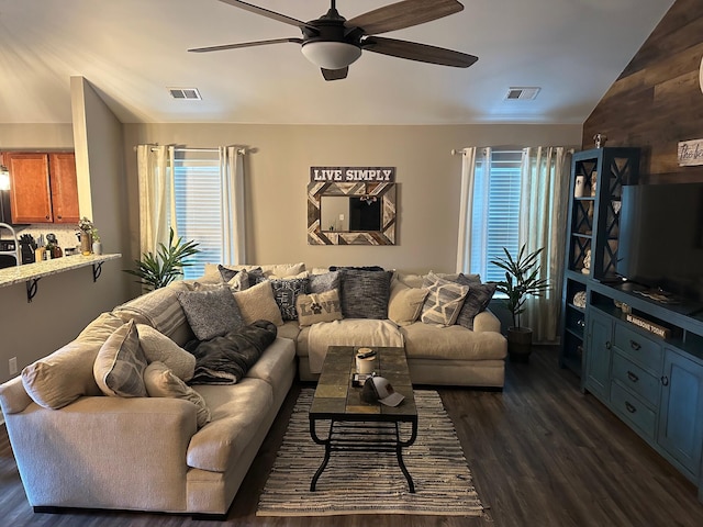 living room featuring ceiling fan, dark wood-type flooring, and vaulted ceiling