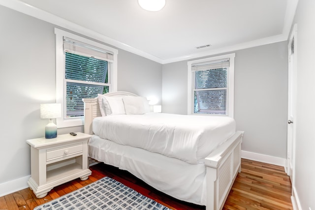 bedroom featuring multiple windows, wood finished floors, and visible vents