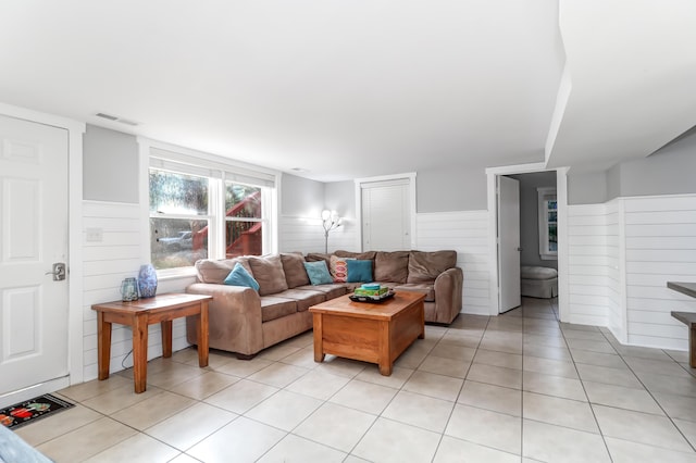 living room with light tile patterned floors, a wainscoted wall, and visible vents